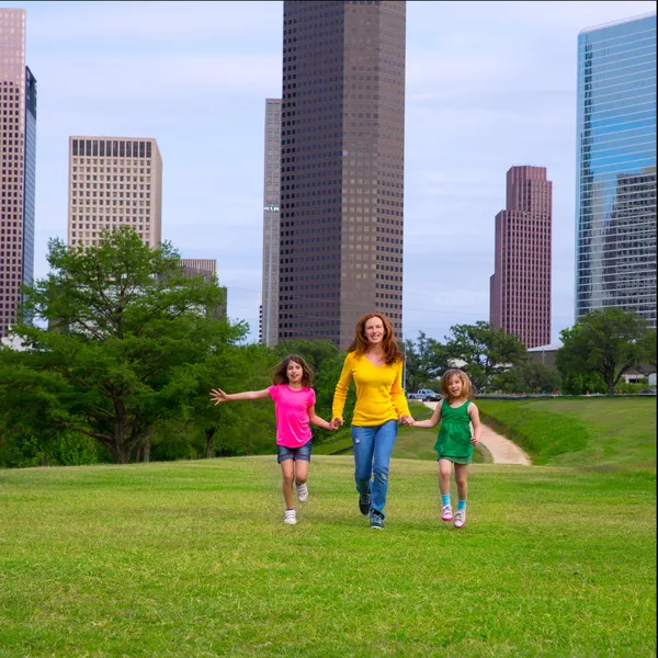 Mother and daughters walking holding hands on city skyline — Stock Photo, Image
