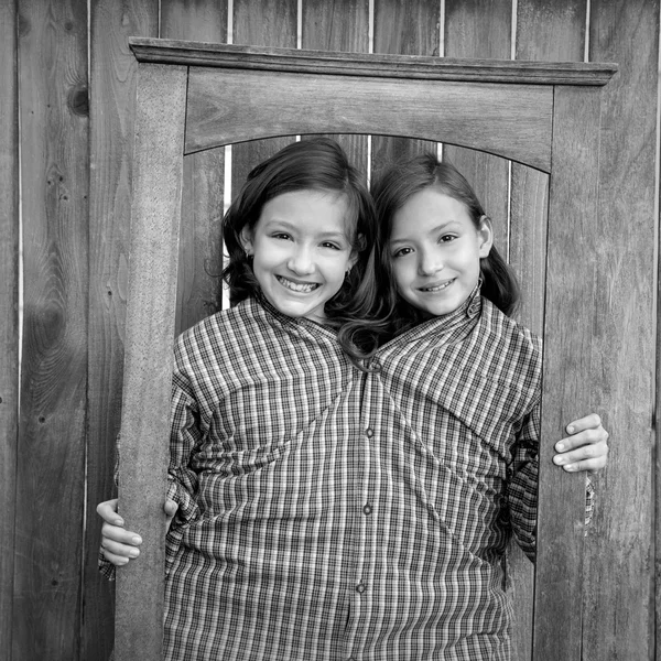 Twin girls fancy dressed up pretending be siamese in frame — стоковое фото