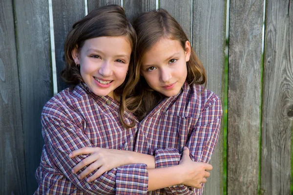 Девочки-близнецы, одетые как сиамцы в рубашку его отца — стоковое фото
