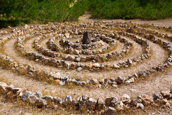 Atlantis spiral sign in Ibiza with stones on soil