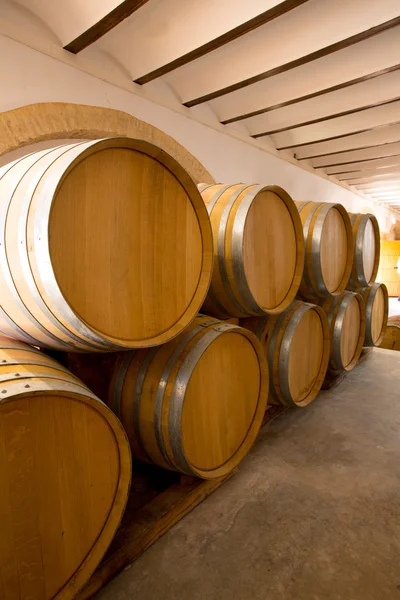 Vino barricas de roble de madera apiladas en una fila en la bodega — Foto de Stock