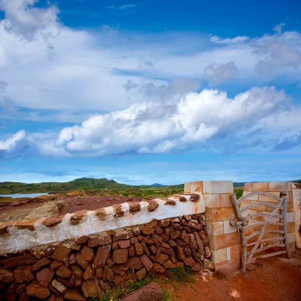 Frimureriet röda stonewall i menorca med staket dörr — Stockfoto