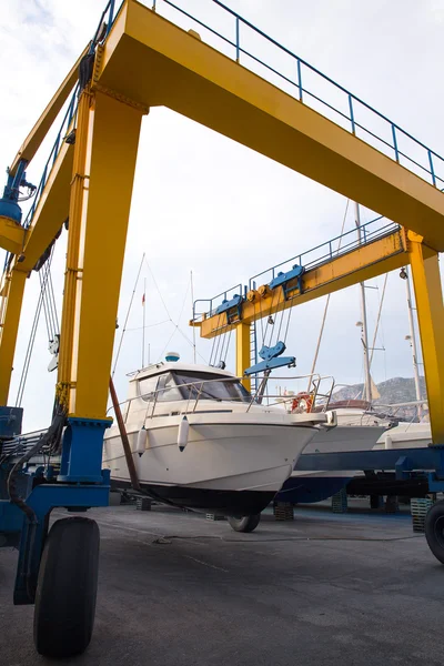 Boat wheel crane elevating motorboat to yearly paint — Stock Photo, Image