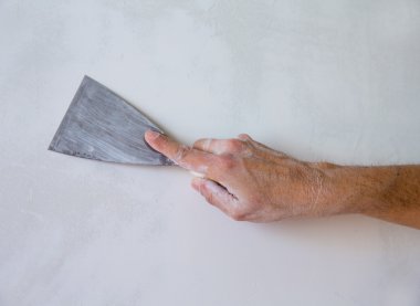 Plastering wall with plaste and plaster spatula trowel clipart