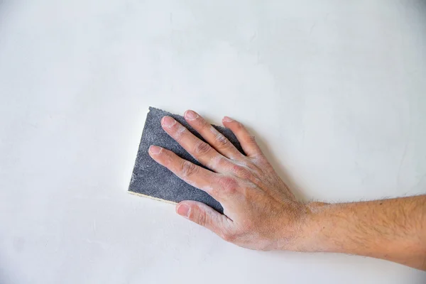 Plastering man hand sanding the plaster — Stock Photo, Image