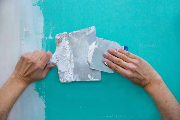 Gesso mãos homem com reboco no drywall gesso — Fotografia de Stock