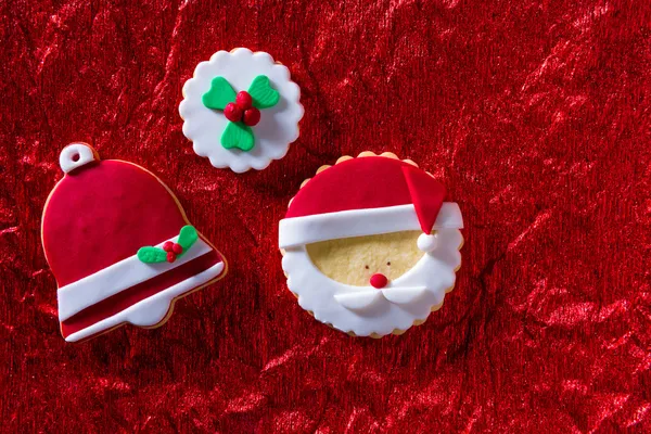 Biscoitos de Natal Santa face e sino de Natal no fundo vermelho — Fotografia de Stock