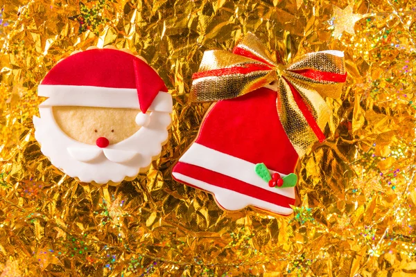 Christmas cookies Xmas red bell ribbon and Santa on golden — Stock Photo, Image