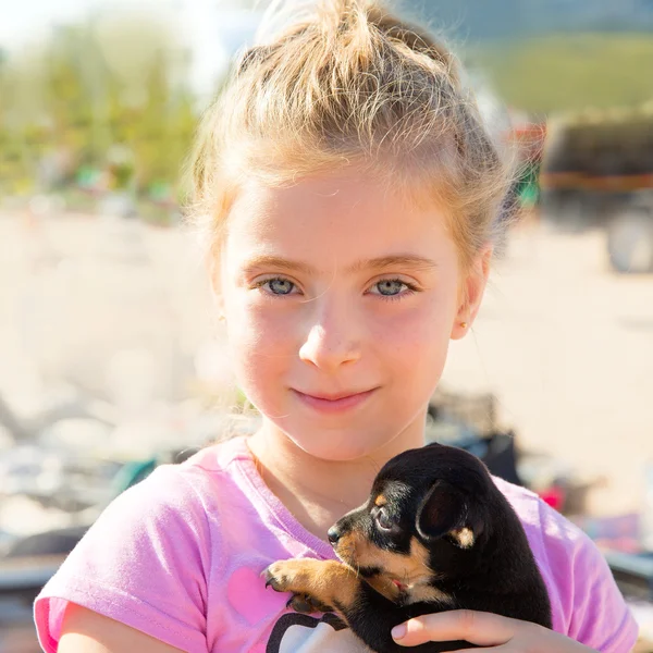 Blond liten flicka som leker med valp hund leende — Stockfoto