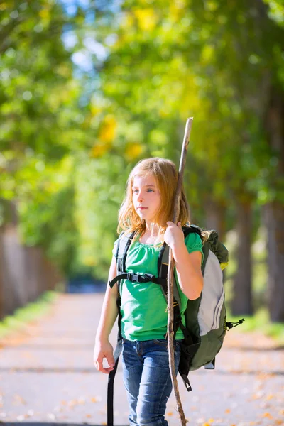 Blond explorer kid girl walking with backpack in autumn trees — Stock Photo, Image