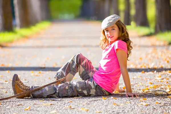 Herbst Kind Mädchen mit Camouflage-Hose sitzt in Bäumen Spur — Stockfoto