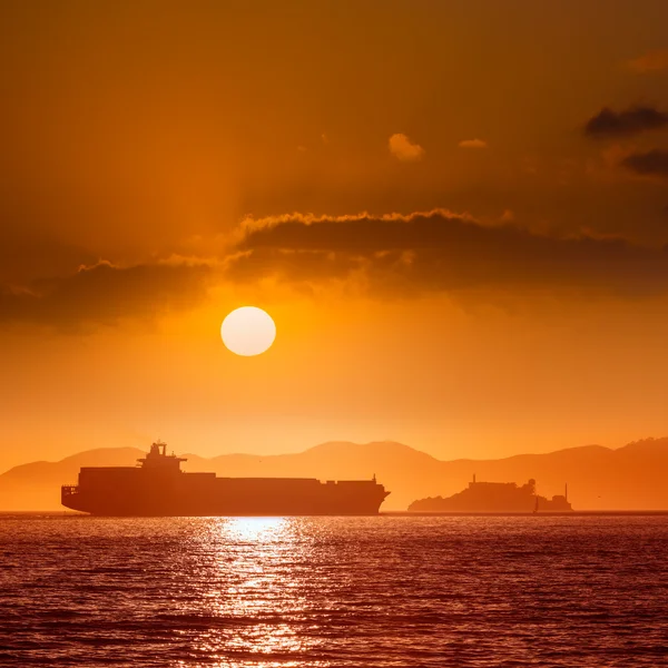 Pénitencier d'Alcatraz île au coucher du soleil et navire marchand — Photo