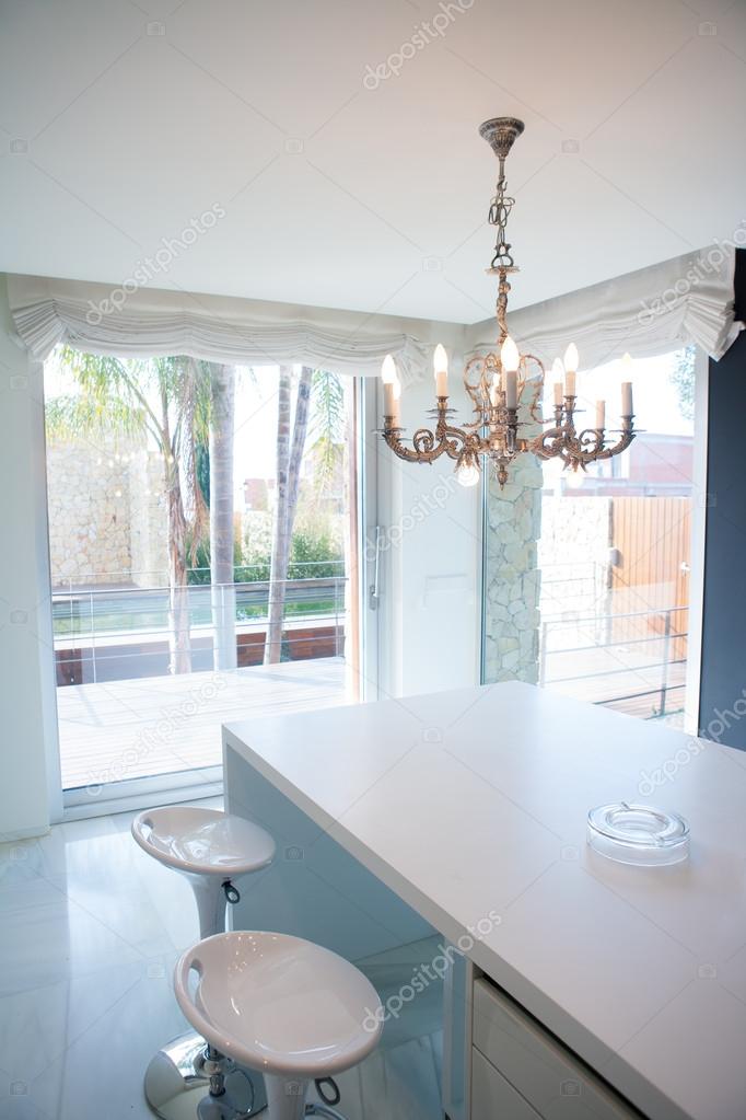 Modern white kitchen table with vintage chandelier