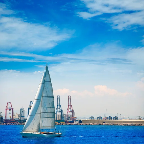 Valencia staden hamnen med segelbåt och kranar i bakgrunden — Stockfoto