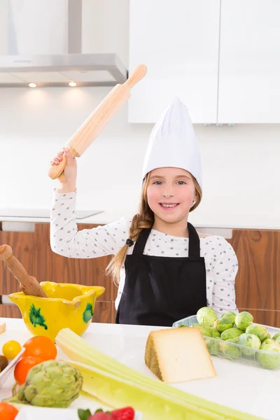 Kid girl chef on countertop funny gesture with roller knead — Stock Photo, Image