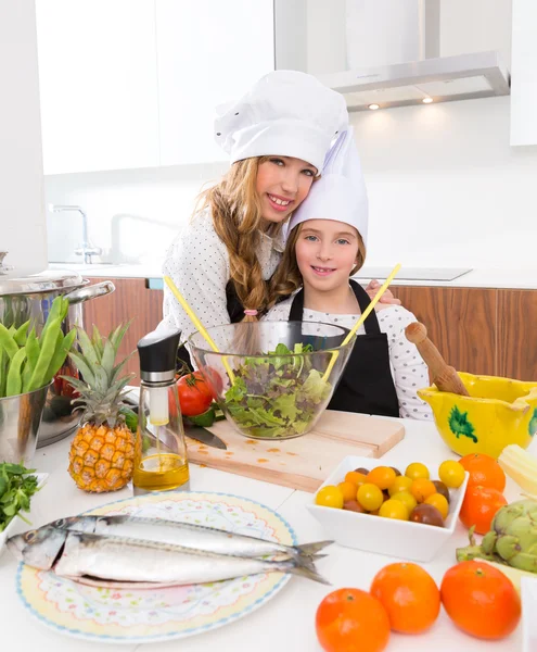 Kid girls junior chef friends hug together in countertop — Stock Photo, Image