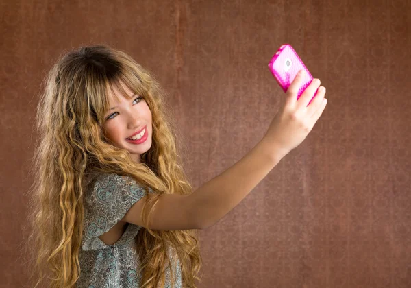Menina criança loira tirando fotos com retrô retrato do telefone móvel — Fotografia de Stock