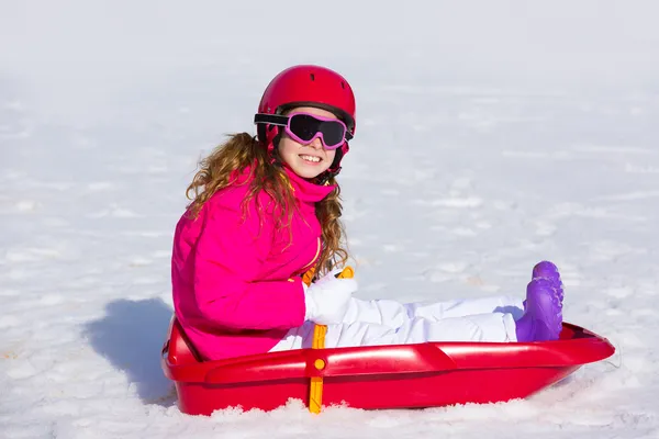 Kid flicka som leker släde i vinter snö — Stockfoto