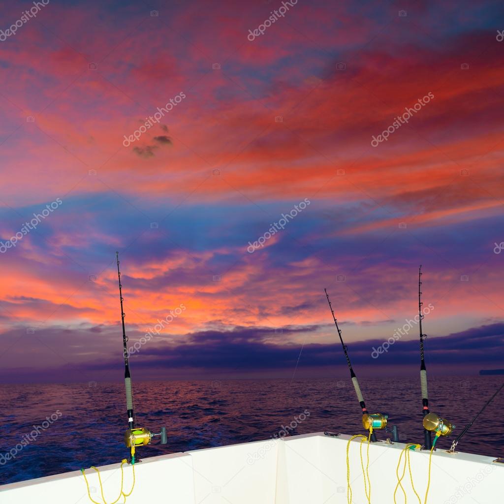 Boat fishing trolling at sunset with rods and reels Stock Photo by