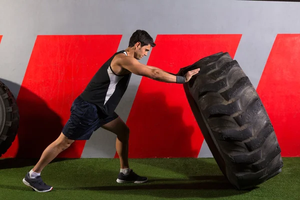 Homem lançando um pneu trator exercício de ginástica — Fotografia de Stock