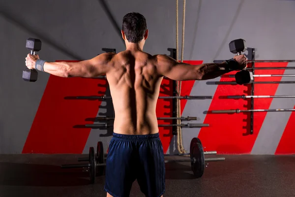 Mancuernas hexagonales hombre entrenamiento vista trasera en el gimnasio —  Fotos de Stock