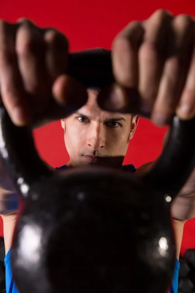Kettlebell man portrait looking through the handle — Stock Photo, Image