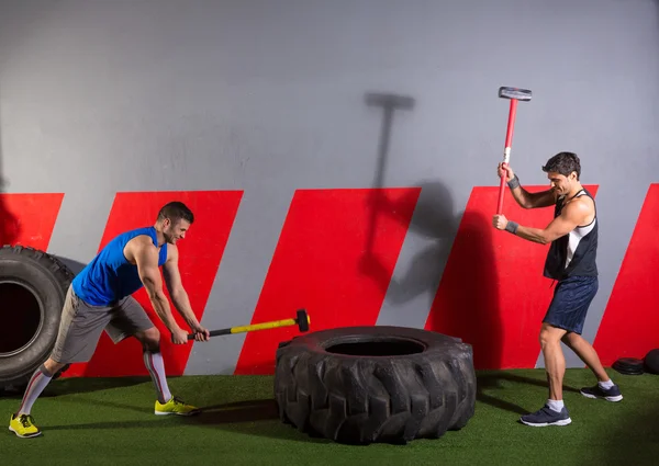 Vorschlaghammer-Reifen trifft Männer beim Training im Fitnessstudio — Stockfoto