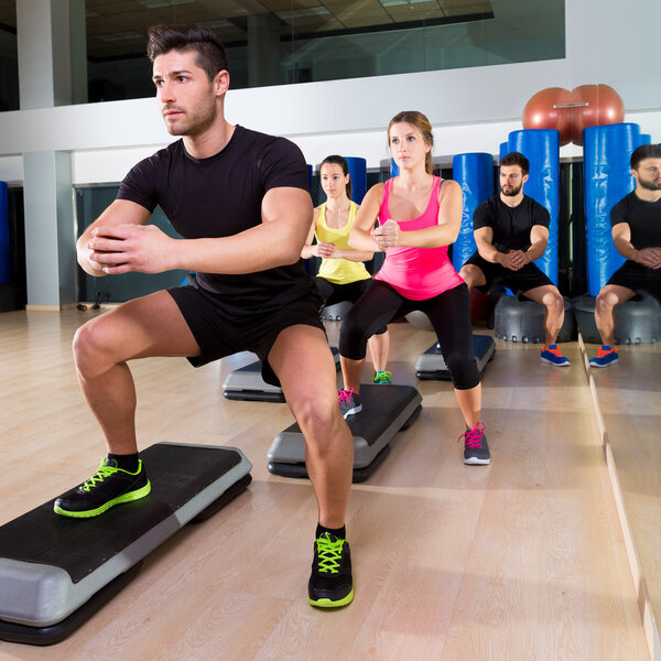 Группа танцев на корточках в фитнес-зале
