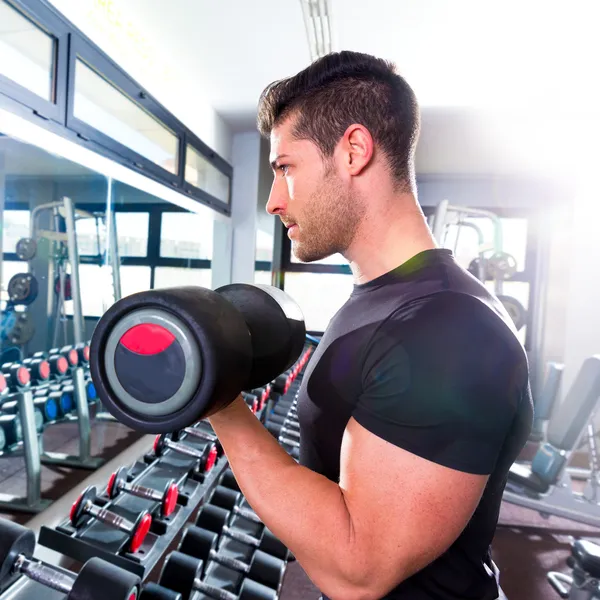 Hombre mancuerna en el gimnasio entrenamiento bíceps fitness —  Fotos de Stock