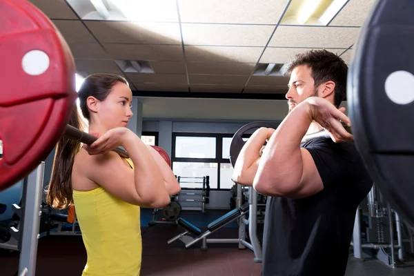 Barbell man en vrouw sporten in de fitnessruimte — Stockfoto