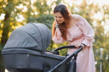 Aile, çocuk ve ebeveyn kavramı - mutlu anne ile bebek arabası Park yürüme.