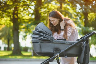 mutlu genç anne ile bebek arabası sonbahar parkta yürüyüş