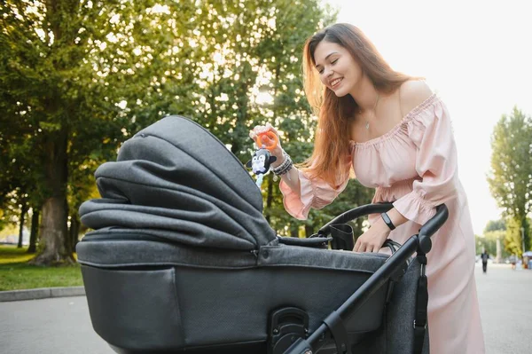Aile, çocuk ve ebeveyn kavramı - mutlu anne ile bebek arabası Park yürüme.