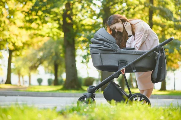 Aile, çocuk ve ebeveyn kavramı - mutlu anne ile bebek arabası Park yürüme.