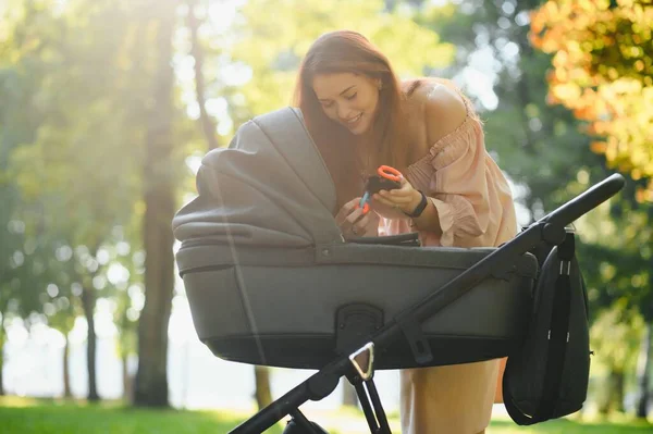 Aile, çocuk ve ebeveyn kavramı - mutlu anne ile bebek arabası Park yürüme.