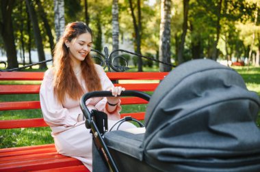 Aile, çocuk ve ebeveyn kavramı - mutlu anne ile bebek arabası Park yürüme.