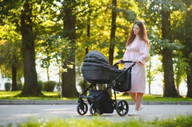 Aile, çocuk ve ebeveyn kavramı - mutlu anne ile bebek arabası Park yürüme.