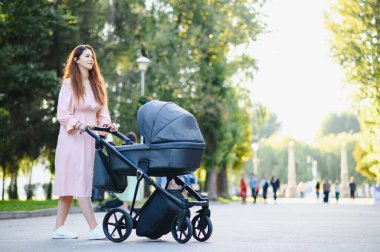Aile, çocuk ve ebeveyn kavramı - mutlu anne ile bebek arabası Park yürüme.