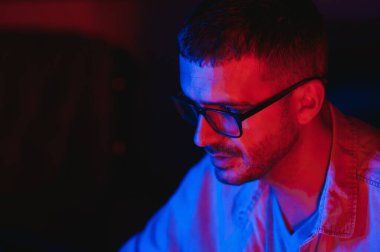 Profesyonel Oyuncu Bilgisayarında Video Oyunu Oynuyor. Çevrimiçi Sanal Oyunlar Turnuvası 'na ya da İnternet Kafe' ye katılıyor. Gözlük takıyor ve mikrofona konuşuyor..