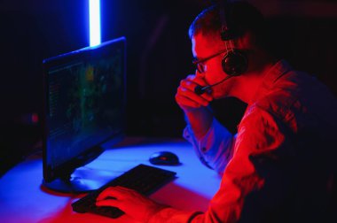 Genç adam çevrimiçi bilgisayar oyunları oynuyor