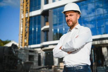 Yeni binanın yanındaki miğferli mimar