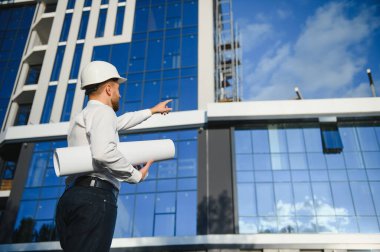 Başarılı mühendis ya da mimar, vinç ve bina inşaatı. Miğfer takan neşeli iş adamı.