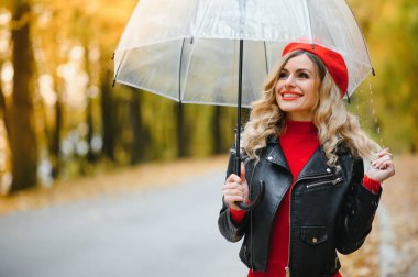 yağmur altında şemsiye ile yürüyen kadın