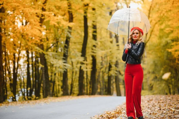 女の子は傘の下で秋の公園で散歩します — ストック写真