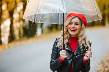 yağmur altında şemsiye ile yürüyen kadın