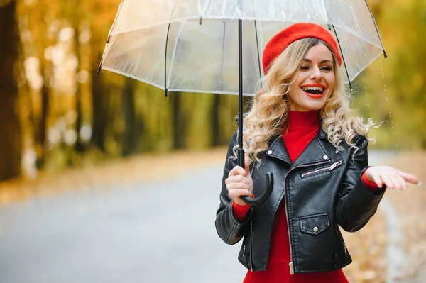 美しい秋の公園で傘を持って雨の中を歩く女性 — ストック写真