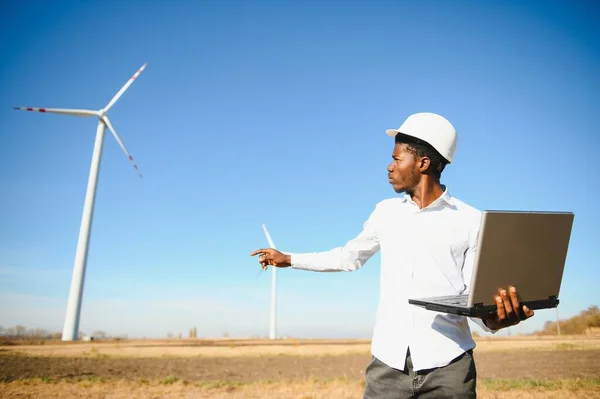 African Engineer Staande Oppottende Laptop Met Windturbine — Stockfoto