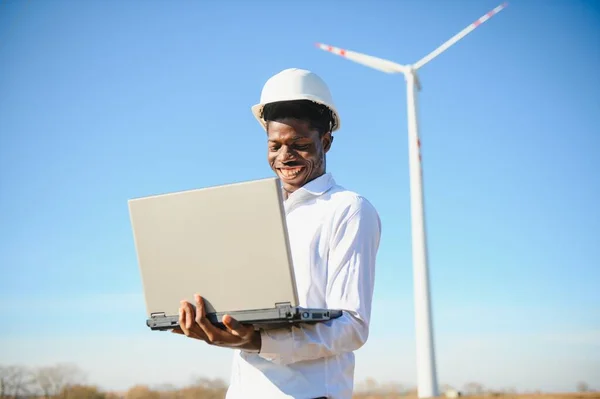 African Engineer Staande Oppottende Laptop Met Windturbine — Stockfoto