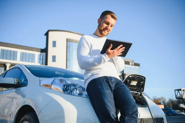 Schöner Junger Mann Beobachtet Wie Sein Auto Auflädt — Stockfoto