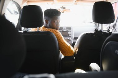 İçki içerken yüksek teknolojili elektrikli aracıyla yakışıklı bir Afro-Amerikalı. Otomatik sürüş aracı kavramı